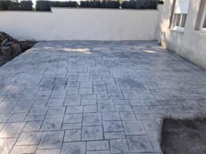 Suelo de hormigón impreso con molde imitación madera y textura realista en terraza exterior